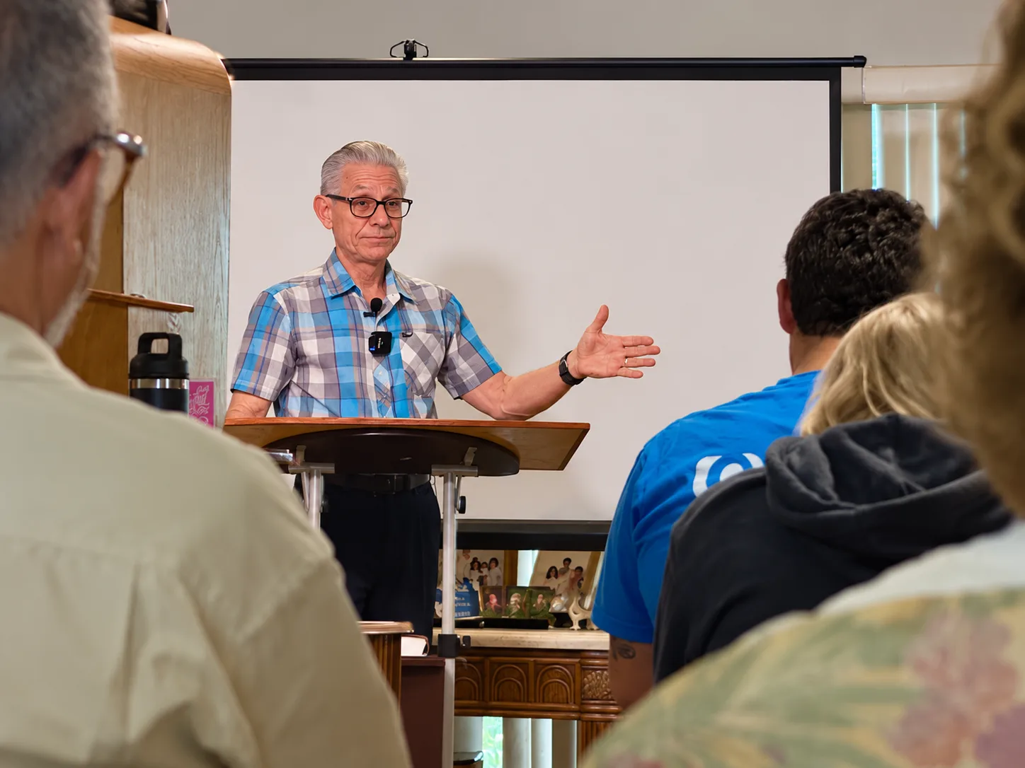 Pastor Frank preaching at a lectern to the gathered congregation